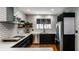 Updated kitchen with white subway tile backsplash, black cabinets, and stainless steel appliances at 5401 N New Jersey St, Indianapolis, IN 46220