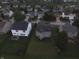 Aerial view of the property showcasing the backyard, nearby houses, and green surroundings at 5502 Floating Leaf Dr, Indianapolis, IN 46237