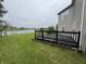 Spacious backyard featuring a wooden deck, a lush green lawn, and a view of the lake at 5502 Floating Leaf Dr, Indianapolis, IN 46237