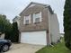 Close up of the brick home showcasing a two-car garage and manicured front yard at 5502 Floating Leaf Dr, Indianapolis, IN 46237