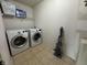 Functional laundry room with modern washer, dryer, and storage shelf at 5502 Floating Leaf Dr, Indianapolis, IN 46237