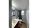 Compact bathroom featuring a red vanity, gray walls, and a window with a gray curtain at 5760 Tim Tam Ct, Indianapolis, IN 46237