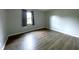 Bedroom featuring neutral colored walls, wood flooring, and window at 5760 Tim Tam Ct, Indianapolis, IN 46237
