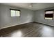 A bedroom with wood-look flooring, light gray walls, and two windows providing natural light at 5760 Tim Tam Ct, Indianapolis, IN 46237