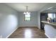 A dining room featuring wood-look flooring, a modern chandelier, and a view into the kitchen area at 5760 Tim Tam Ct, Indianapolis, IN 46237