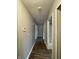 A long hallway with wood-look flooring, light gray walls, and several doorways at 5760 Tim Tam Ct, Indianapolis, IN 46237