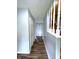 A hallway featuring wood floors and light blue walls, with a staircase on the right at 5760 Tim Tam Ct, Indianapolis, IN 46237