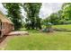 Expansive backyard featuring a wooden deck, lush lawn, and a playground for outdoor enjoyment at 6030 Riverview Dr, Indianapolis, IN 46208