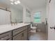 Light-filled bathroom features a patterned floor, gray vanity, and a large mirror at 6030 Riverview Dr, Indianapolis, IN 46208