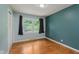 Bedroom featuring hardwood floors, a large window, and a closet with sliding doors at 6030 Riverview Dr, Indianapolis, IN 46208