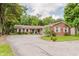 View of charming single story brick home featuring an asphalt driveway and mature landscaping at 6030 Riverview Dr, Indianapolis, IN 46208