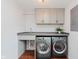 Laundry room features a modern washer and dryer, cabinets, and a sink at 6030 Riverview Dr, Indianapolis, IN 46208