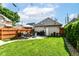 Landscaped backyard with green grass, string lights, patio furniture, and wood fence at 635 E 10Th St, Indianapolis, IN 46202