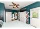 Bright bedroom with ceiling fan, closets, access door, and dark accent walls at 635 E 10Th St, Indianapolis, IN 46202