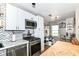 Bright kitchen features white cabinets, stainless appliances, herringbone backsplash, and dining area at 635 E 10Th St, Indianapolis, IN 46202