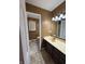 Bathroom featuring tile flooring, vanity, sink, mirror, lighting, toilet, and window with blinds at 6609 N Tuxedo Ln, Indianapolis, IN 46220