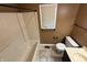 Bathroom with tub, tile flooring, toilet, and window at 6609 N Tuxedo Ln, Indianapolis, IN 46220