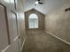 Neutral bedroom with vaulted ceiling, large window, and plush carpet at 6609 N Tuxedo Ln, Indianapolis, IN 46220