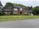 Beautiful brick home with black roof, manicured lawn, and professional landscaping at 6609 N Tuxedo Ln, Indianapolis, IN 46220