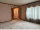 Cozy living room featuring neutral carpet, light pink walls, and a view of the front entry at 6609 N Tuxedo Ln, Indianapolis, IN 46220