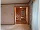 Living room featuring neutral carpet, light pink walls, and a view of the stairway at 6609 N Tuxedo Ln, Indianapolis, IN 46220
