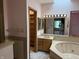 Main bathroom features a soaking tub, single vanity, and walk-in closet access at 6609 N Tuxedo Ln, Indianapolis, IN 46220
