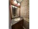 Elegant powder room with decorative mirror, and wallpaper at 6609 N Tuxedo Ln, Indianapolis, IN 46220