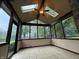 Inviting screened porch featuring skylights, ceiling fan, tiled floor and large windows at 6609 N Tuxedo Ln, Indianapolis, IN 46220