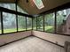Enclosed sunroom with tile flooring and large windows overlooking the landscaped backyard at 6609 N Tuxedo Ln, Indianapolis, IN 46220