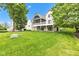 Spacious backyard featuring a manicured lawn and brick home with a screened-in porch and deck at 6610 Royal Oakland Dr, Indianapolis, IN 46236