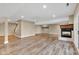 Spacious basement area featuring a cozy fireplace and light wood floors at 6610 Royal Oakland Dr, Indianapolis, IN 46236
