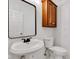 Bathroom featuring a toilet, sink, mirror, and wooden storage cabinet at 6610 Royal Oakland Dr, Indianapolis, IN 46236