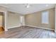 A cozy bedroom featuring light hardwood floors and a doorway to an ensuite bathroom at 6610 Royal Oakland Dr, Indianapolis, IN 46236