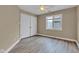 Cozy bedroom featuring wood-look floors, a ceiling fan, and a double-door closet at 6610 Royal Oakland Dr, Indianapolis, IN 46236