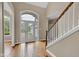 Bright foyer features wood floors, a staircase with white railings, and decorative front door glass at 6610 Royal Oakland Dr, Indianapolis, IN 46236