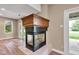 Living area fireplace with a wood mantle, next to glass doors and natural light at 6610 Royal Oakland Dr, Indianapolis, IN 46236
