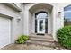 Close-up of the home's front door with a white frame, ornate glass and manicured landscaping at 6610 Royal Oakland Dr, Indianapolis, IN 46236