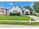Charming white brick home featuring a well-manicured lawn and a paved driveway leading to the entrance at 6610 Royal Oakland Dr, Indianapolis, IN 46236