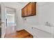 Functional laundry area with wash basin, overhead cabinets, and adjacent access to the main living areas at 6610 Royal Oakland Dr, Indianapolis, IN 46236