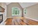 Bright living room featuring a fireplace, hardwood floors, large windows, and vaulted ceilings at 6610 Royal Oakland Dr, Indianapolis, IN 46236