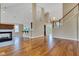 Open living space showcasing hardwood floors, a fireplace, staircase, and abundant natural light at 6610 Royal Oakland Dr, Indianapolis, IN 46236