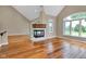 Open living room with a fireplace, hardwood floors, vaulted ceilings and large picture window at 6610 Royal Oakland Dr, Indianapolis, IN 46236