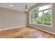 Sun-filled living room with hardwood floors, large windows, and a decorative chandelier at 6610 Royal Oakland Dr, Indianapolis, IN 46236