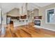 Open-concept space featuring a fireplace, breakfast bar, hardwood floors, and natural light at 6610 Royal Oakland Dr, Indianapolis, IN 46236
