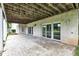 Covered patio with exposed wooden beams and multiple sliding glass doors to the home's interior at 6610 Royal Oakland Dr, Indianapolis, IN 46236