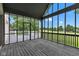 Enjoy views of the green lawn from this enclosed porch featuring a gray wood floor at 6610 Royal Oakland Dr, Indianapolis, IN 46236