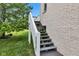 Exterior stairs with a white railing leading up to a backyard deck and the house at 6610 Royal Oakland Dr, Indianapolis, IN 46236