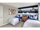 Tastefully decorated bedroom with two beds and a nautical themed accent wall, showcasing artistic flair at 6702 Halsey St, Zionsville, IN 46077