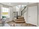 Inviting foyer with wood floors, staircase, and ample natural light from the nearby windows at 6702 Halsey St, Zionsville, IN 46077