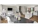 Open-concept living area with modern decor, stairs, an adjacent kitchen, and hardwood flooring at 6702 Halsey St, Zionsville, IN 46077